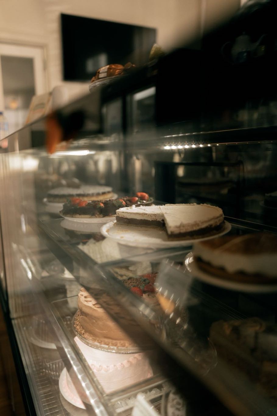 A display of cakes and traybakes under a glass dome