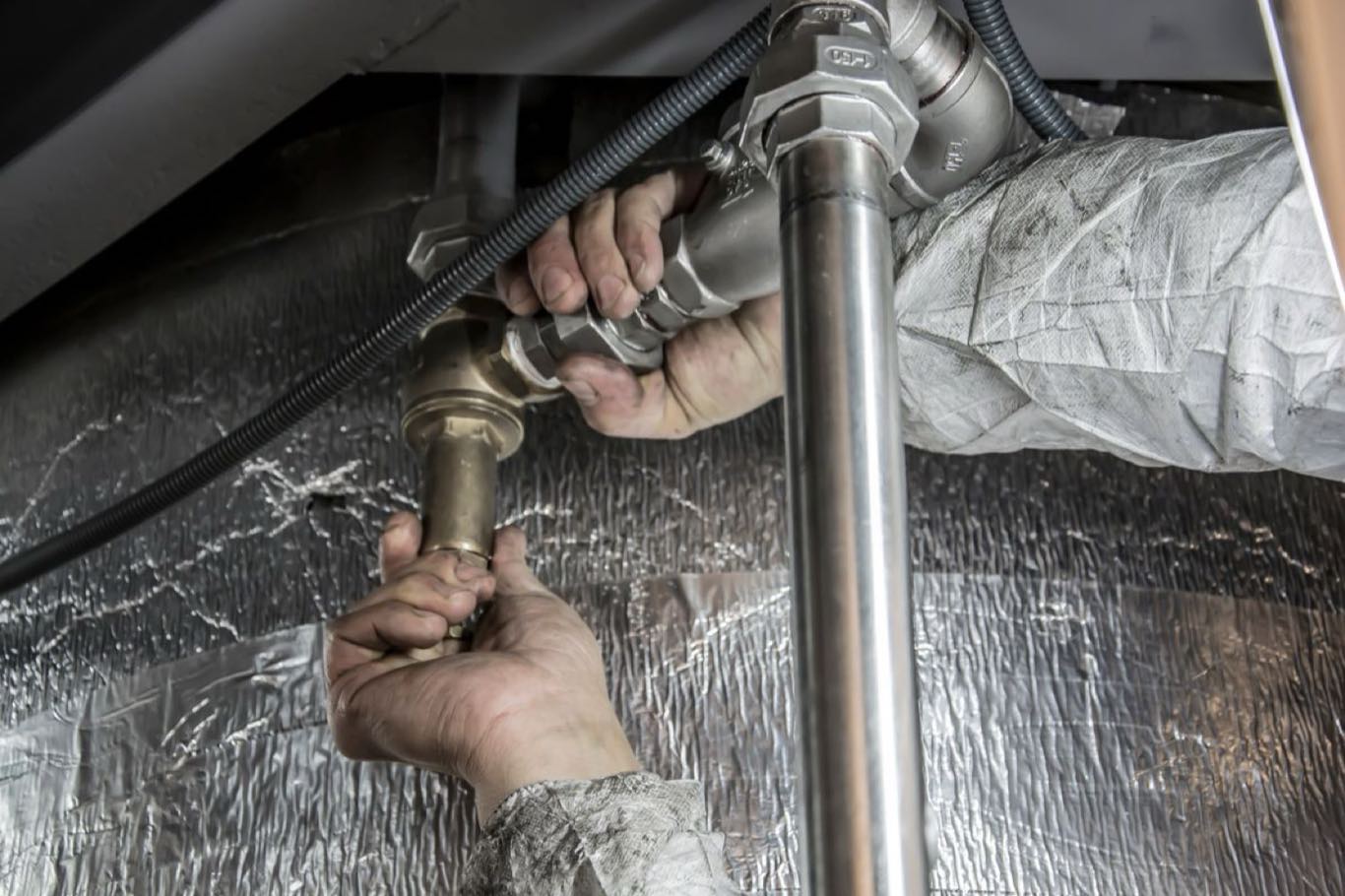 A plumber fitting new pipework by hand